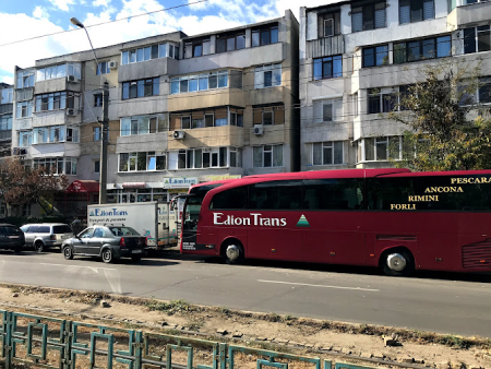 Autocar Edion Trans roșu parcat în fața sediului Edion Trans